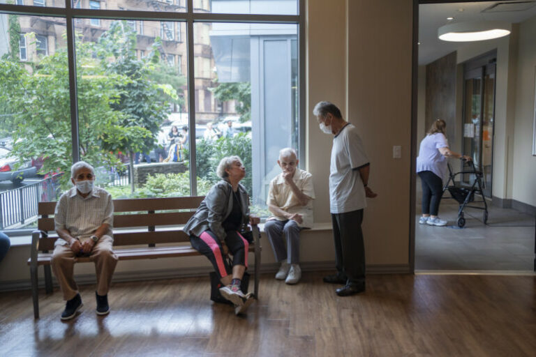 Older adults in a senior center in front of windows