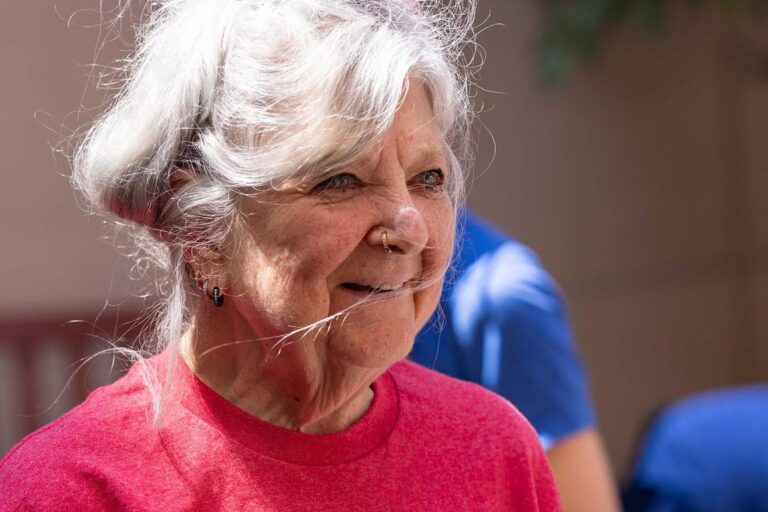 An older woman in a pink shirt exercising at Encore Community Center